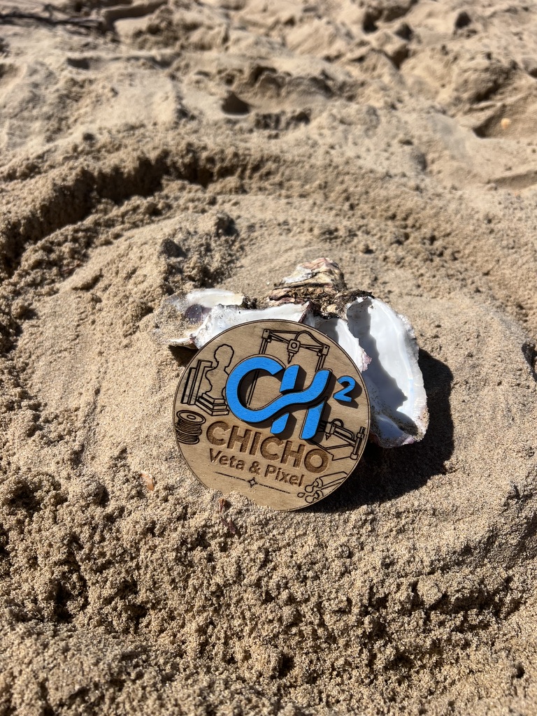 Logo artesanal de Veta y Pixel fotografiado en la playa de El Rompido